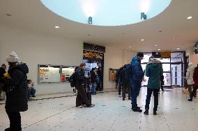 Travelers Waiting For Their Train In A Station Hall