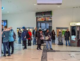 Travelers Waiting For Their Train In A Station Hall