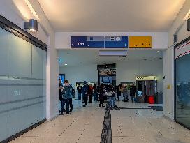 Travelers Waiting For Their Train In A Station Hall