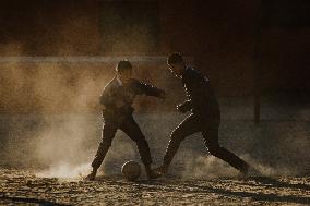 School Students Playing Football Barefoot