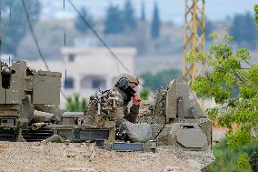 Israeli Soldiers Gather Behind Rubble In A Southern Lebanese Village