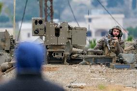 Israeli Soldiers Gather Behind Rubble In A Southern Lebanese Village