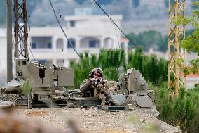 Israeli Soldiers Gather Behind Rubble In A Southern Lebanese Village