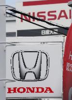 Signs and logos of Honda Motor Co. and Nissan Motor Co.
