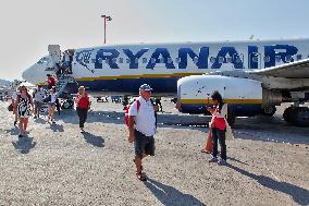 Passengers Disembark From A Ryanair Airplane On Santorini Island