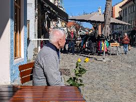 Elderly Man Holding Two Yellow Roses