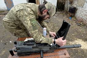 Serviceman of 57th Separate Motorized Brigade maintains American MK-19 grenade launcher