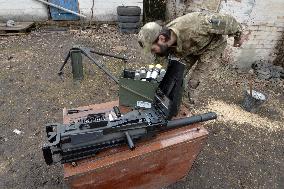 Serviceman of 57th Separate Motorized Brigade maintains American MK-19 grenade launcher