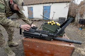 Serviceman of 57th Separate Motorized Brigade maintains American MK-19 grenade launcher