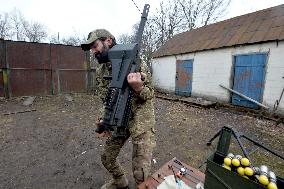 Serviceman of 57th Separate Motorized Brigade maintains American MK-19 grenade launcher