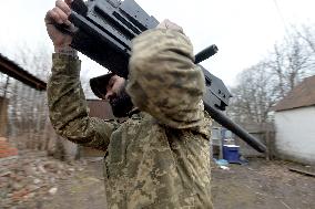 Serviceman of 57th Separate Motorized Brigade maintains American MK-19 grenade launcher