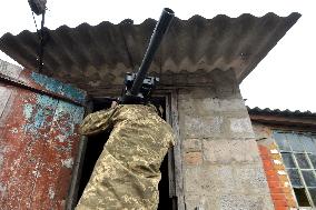 Serviceman of 57th Separate Motorized Brigade maintains American MK-19 grenade launcher