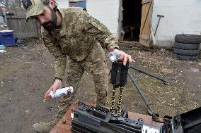 Serviceman of 57th Separate Motorized Brigade maintains American MK-19 grenade launcher