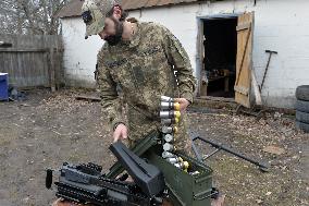 Serviceman of 57th Separate Motorized Brigade maintains American MK-19 grenade launcher