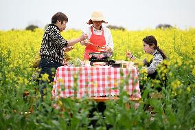 Tourists Eat Hot Pot Among Blooming Rapeseed Flowers in Nanjing