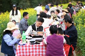 Tourists Eat Hot Pot Among Blooming Rapeseed Flowers in Nanjing