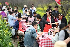 Tourists Eat Hot Pot Among Blooming Rapeseed Flowers in Nanjing