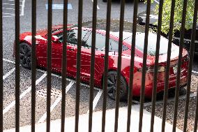 A red Tesla is parked on West Executive Drive