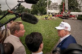 President Trump speaks to the press while workers instals a new flag pole on South Lawn