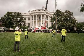 President Trump speaks to the press while workers install a new flag pole on South Lawn