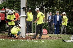 President Trump speaks to the press while workers install a new flag pole on South Lawn