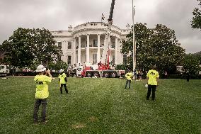 President Trump speaks to the press while workers install a new flag pole on South Lawn