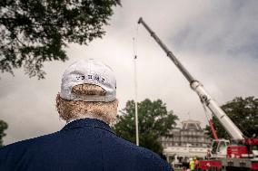 President Trump speaks to the press while workers installs a new flag pole on South Lawn