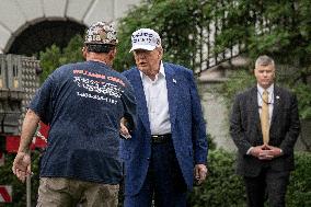 President Trump speaks to the press while workers install a new flag pole on South Lawn