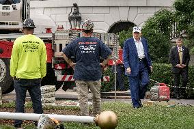 President Trump speaks to the press while workers install a new flag pole on South Lawn