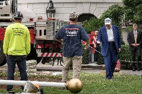President Trump speaks to the press while workers install a new flag pole on South Lawn