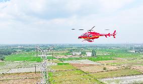 Helicopters Conduct Aerial Patrols on Ultra-high Voltage Transmission Lines