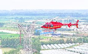 Helicopters Conduct Aerial Patrols on Ultra-high Voltage Transmission Lines