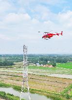 Helicopters Conduct Aerial Patrols on Ultra-high Voltage Transmission Lines