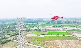 Helicopters Conduct Aerial Patrols on Ultra-high Voltage Transmission Lines