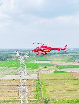 Helicopters Conduct Aerial Patrols on Ultra-high Voltage Transmission Lines