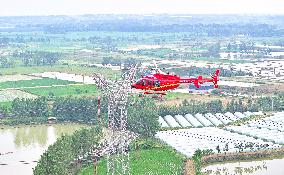 Helicopters Conduct Aerial Patrols on Ultra-high Voltage Transmission Lines