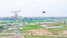 Helicopters Conduct Aerial Patrols on Ultra-high Voltage Transmission Lines