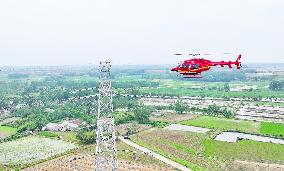 Helicopters Conduct Aerial Patrols on Ultra-high Voltage Transmission Lines
