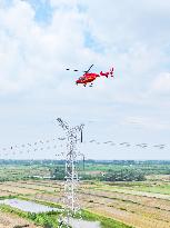 Helicopters Conduct Aerial Patrols on Ultra-high Voltage Transmission Lines