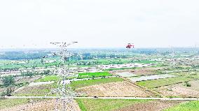 Helicopters Conduct Aerial Patrols on Ultra-high Voltage Transmission Lines