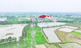 Helicopters Conduct Aerial Patrols on Ultra-high Voltage Transmission Lines