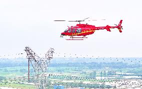 Helicopters Conduct Aerial Patrols on Ultra-high Voltage Transmission Lines