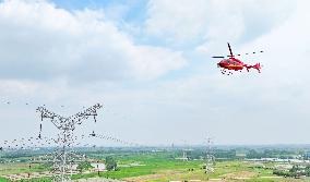 Helicopters Conduct Aerial Patrols on Ultra-high Voltage Transmission Lines