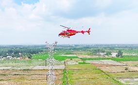 Helicopters Conduct Aerial Patrols on Ultra-high Voltage Transmission Lines