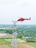 Helicopters Conduct Aerial Patrols on Ultra-high Voltage Transmission Lines
