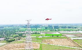 Helicopters Conduct Aerial Patrols on Ultra-high Voltage Transmission Lines