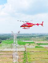 Helicopters Conduct Aerial Patrols on Ultra-high Voltage Transmission Lines