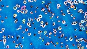 Tourists Enjoy Coolness in Water Park