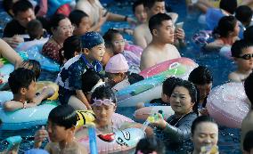 Tourists Enjoy Coolness in Water Park