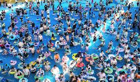 Tourists Enjoy Coolness in Water Park